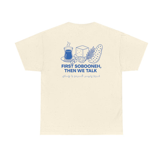 Beige Mashtee T-shirt featuring blue Persian breakfast graphic with tea, bread, cheese, and text “First Sobooneh Then We Talk”